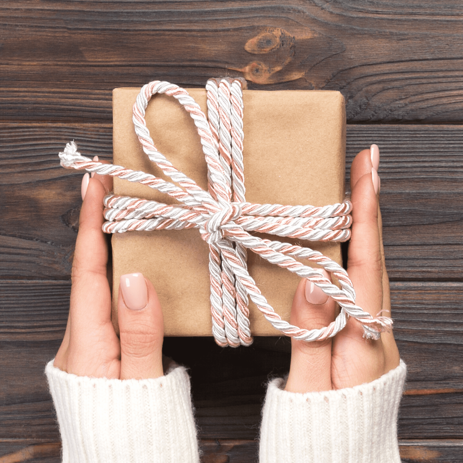 woman's hands holding a wrapped gift